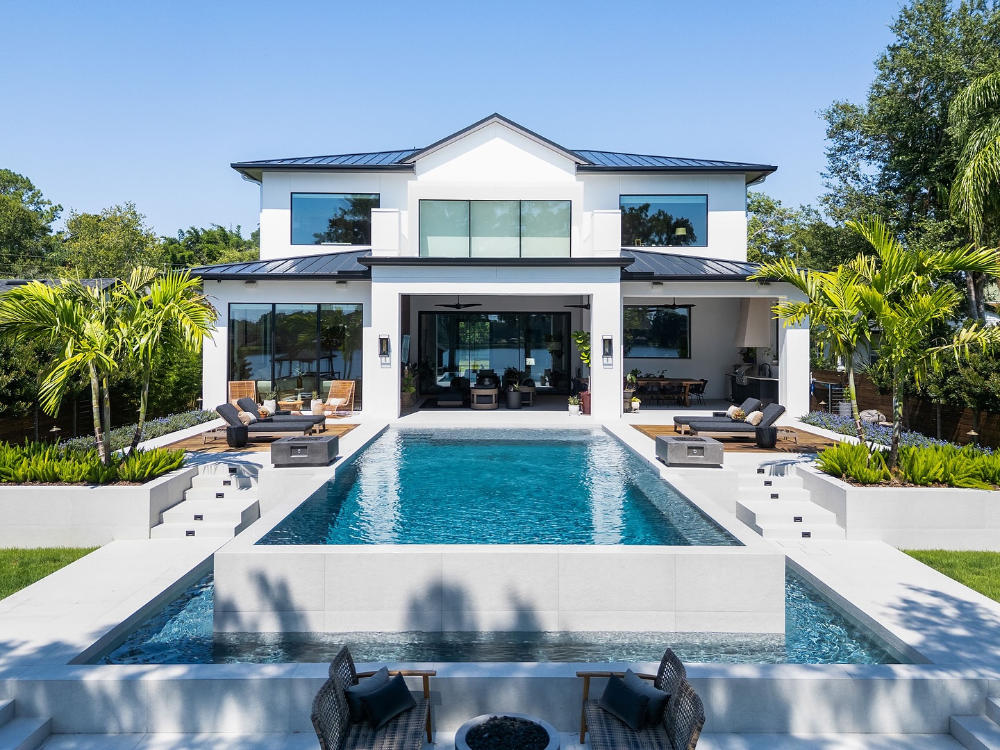 Modern luxury home with infinity pool and tropical landscape by William Thomas Design Orlando