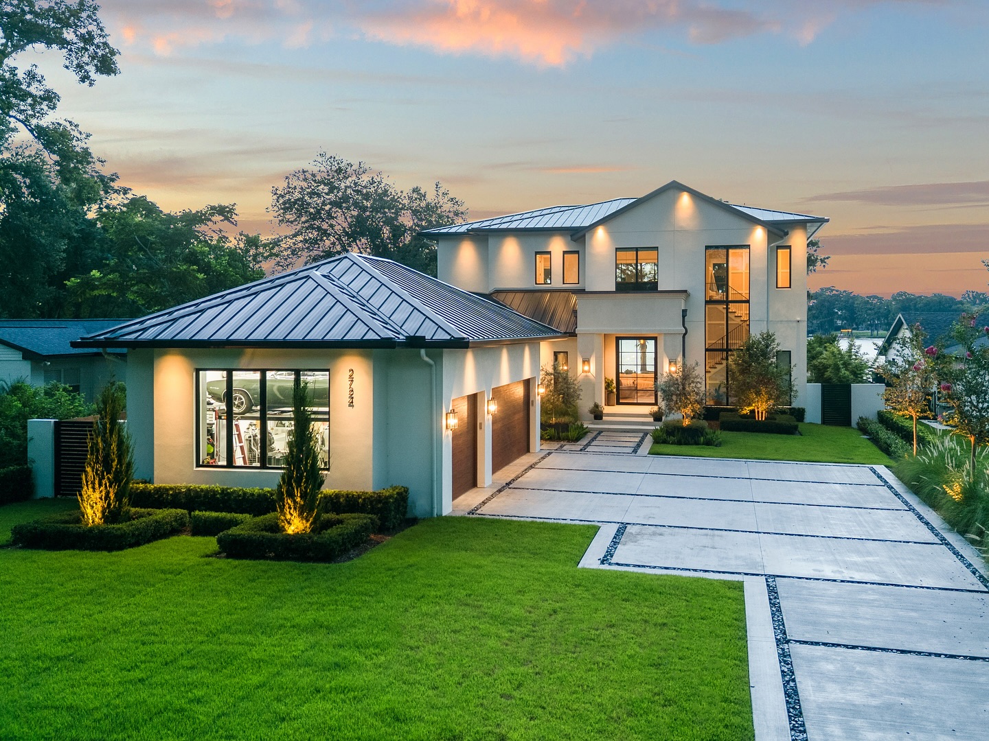 Modern custom home at sunset with landscape lighting